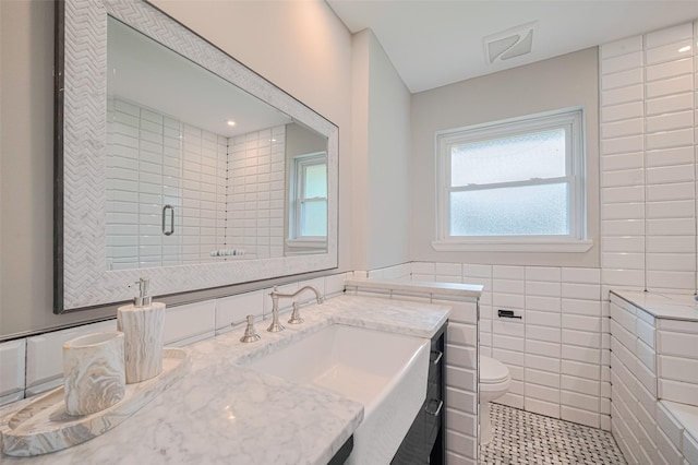 5123 Saxon Dr, Houston, TX 77092 - bathroom featuring vanity, tile patterned floors, tile walls, and a shower