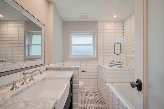 5123 Saxon Dr, Houston, TX 77092 - bathroom with tile walls, vanity,  shower combination, and recessed lighting