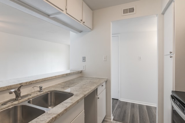 3025 Walnut Bend Ln Unit 37, Houston, TX 77042 - kitchen featuring wood finished floors, white cabinetry, range, and light stone countertops
