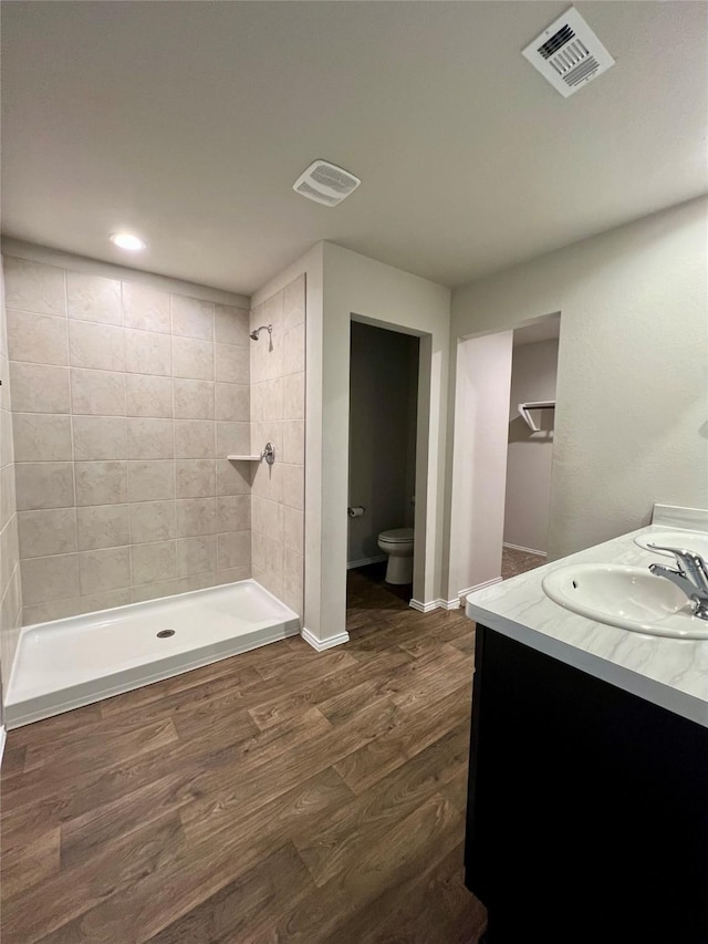 21540 Rustic Elm Dr, New Caney, TX 77357 - bathroom featuring wood finished floors, vanity, a tile shower, and recessed lighting
