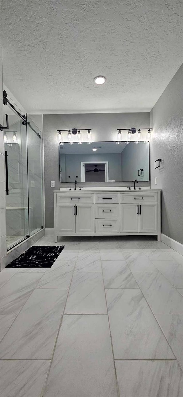 47 W Dansby Dr, Galveston, TX 77551 - bathroom with double vanity, a textured ceiling, marble finish floors, a stall shower, and recessed lighting