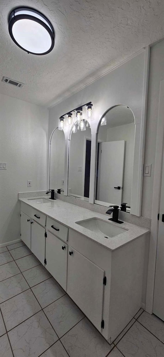 47 W Dansby Dr, Galveston, TX 77551 - full bathroom featuring a textured ceiling, marble finish floors, and double vanity
