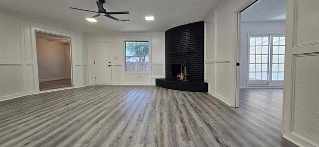 47 W Dansby Dr, Galveston, TX 77551 - unfurnished living room featuring a decorative wall, wood finished floors, ceiling fan, and a fireplace