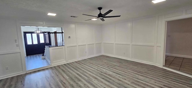 47 W Dansby Dr, Galveston, TX 77551 - empty room with a decorative wall, wood finished floors, a ceiling fan, and a chandelier