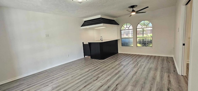 47 W Dansby Dr, Galveston, TX 77551 - unfurnished living room with wood finished floors, ceiling fan, and a textured ceiling