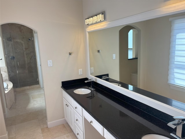 607 Oakley St Unit 5, Houston, TX 77006 - bathroom with a shower stall, double vanity, tile patterned floors, and plenty of natural light