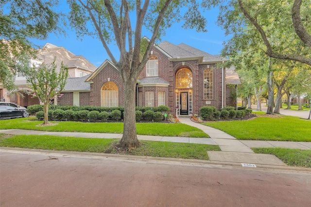 3402 Haywood Ct, Sugar Land, TX 77478 - traditional-style house with brick siding, a front lawn, and roof with shingles