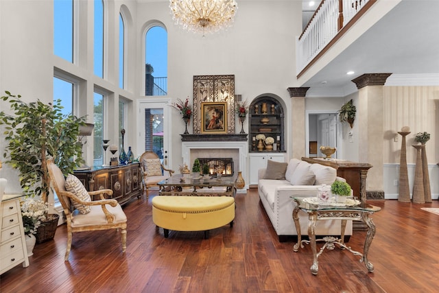 3402 Haywood Ct, Sugar Land, TX 77478 - living room with a high ceiling, a warm lit fireplace, crown molding, a chandelier, and wood finished floors