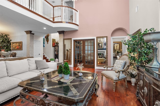 3402 Haywood Ct, Sugar Land, TX 77478 - living room featuring a towering ceiling, decorative columns, wood finished floors, french doors, and stairs
