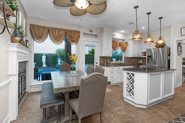 3402 Haywood Ct, Sugar Land, TX 77478 - kitchen featuring stainless steel fridge, dark countertops, white cabinets, a ceiling fan, and tasteful backsplash
