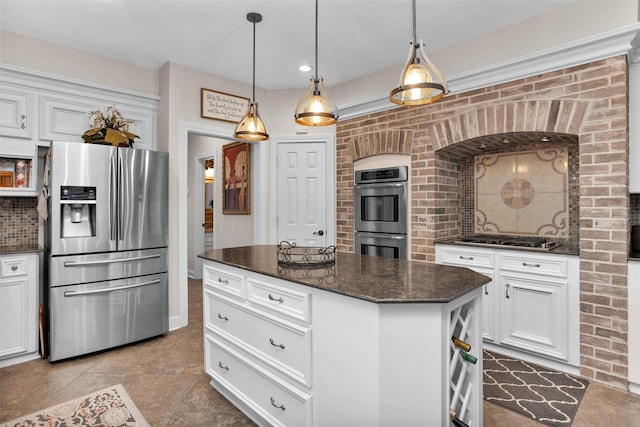 3402 Haywood Ct, Sugar Land, TX 77478 - kitchen featuring appliances with stainless steel finishes, white cabinetry, hanging light fixtures, dark stone countertops, and a kitchen island