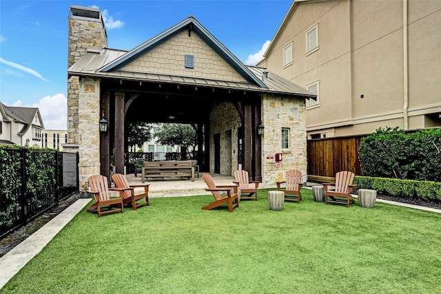 8325 Barberry Branch St, Houston, TX 77055 - back of house featuring a standing seam roof, stone siding, a fenced backyard, a chimney, and a metal roof