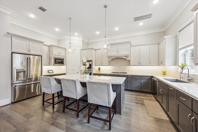 8325 Barberry Branch St, Houston, TX 77055 - kitchen with stainless steel appliances, a kitchen island, a kitchen bar, dark wood-type flooring, and crown molding
