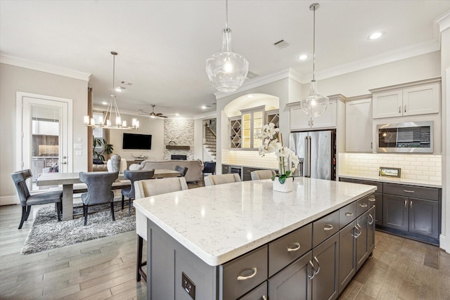 8325 Barberry Branch St, Houston, TX 77055 - kitchen featuring stainless steel appliances, ceiling fan, decorative backsplash, a center island, and crown molding