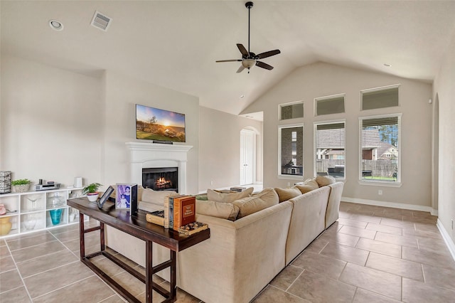 18115 Stari Most Ln, Houston, TX 77044 - living room with ceiling fan, a warm lit fireplace, light tile patterned flooring, and high vaulted ceiling