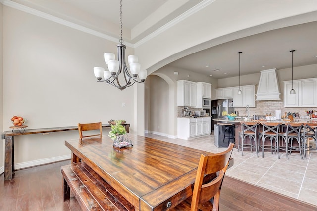 18115 Stari Most Ln, Houston, TX 77044 - dining area with light wood-style flooring, arched walkways, and a chandelier