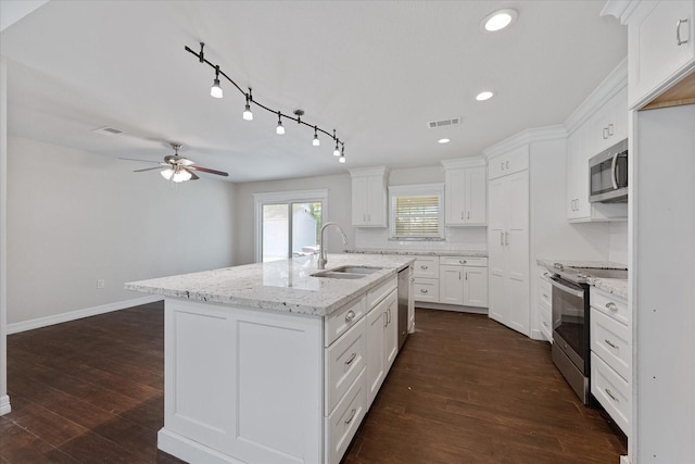 1503 Briar Cliff St, Conroe, TX 77385 - kitchen featuring appliances with stainless steel finishes, a ceiling fan, white cabinetry, a center island with sink, and recessed lighting