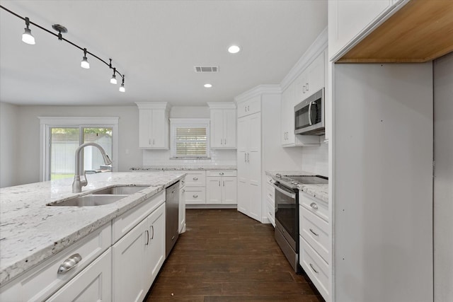 1503 Briar Cliff St, Conroe, TX 77385 - kitchen featuring appliances with stainless steel finishes, white cabinetry, dark wood-style floors, light stone countertops, and recessed lighting