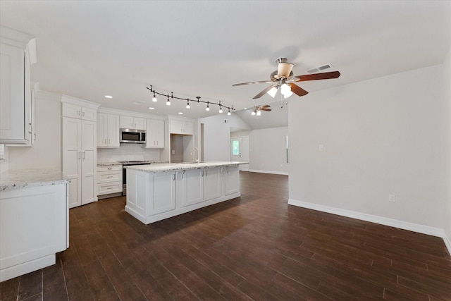 1503 Briar Cliff St, Conroe, TX 77385 - kitchen featuring stainless steel appliances, a ceiling fan, backsplash, an island with sink, and white cabinetry