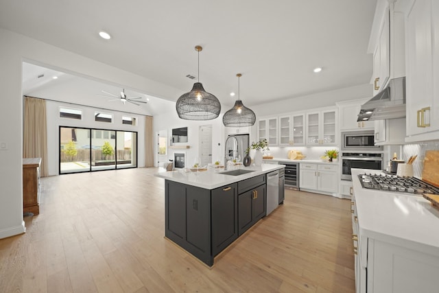 24914 Heather Glade Trl, Tomball, TX 77375 - kitchen with stainless steel appliances, under cabinet range hood, white cabinetry, wine cooler, and light countertops