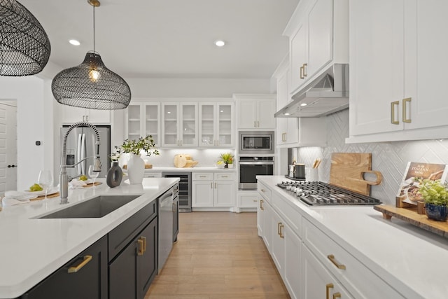 24914 Heather Glade Trl, Tomball, TX 77375 - kitchen featuring stainless steel appliances, under cabinet range hood, white cabinetry, light countertops, and recessed lighting