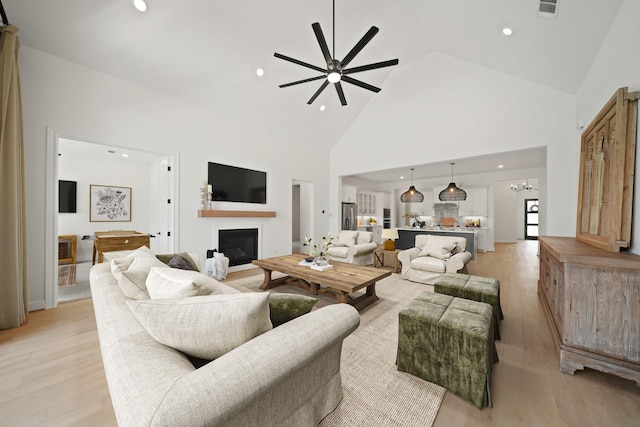 24914 Heather Glade Trl, Tomball, TX 77375 - living area featuring a glass covered fireplace, high vaulted ceiling, light wood-type flooring, ceiling fan, and recessed lighting