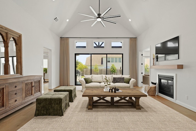24914 Heather Glade Trl, Tomball, TX 77375 - living area with high vaulted ceiling, plenty of natural light, a glass covered fireplace, a ceiling fan, and wood finished floors