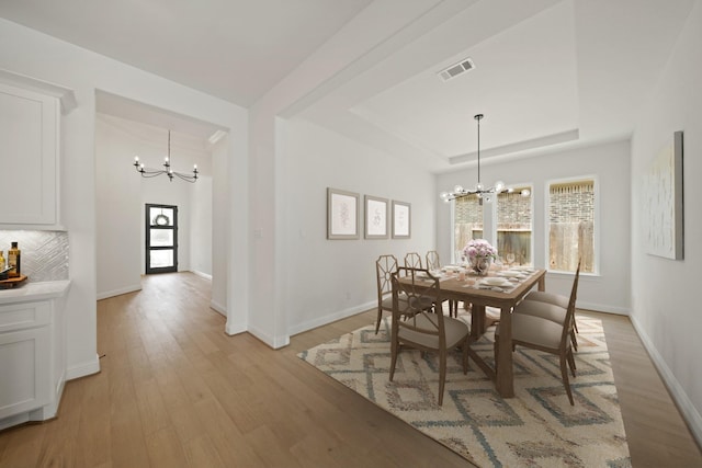 24914 Heather Glade Trl, Tomball, TX 77375 - dining room featuring a chandelier, light wood-style flooring, and a raised ceiling