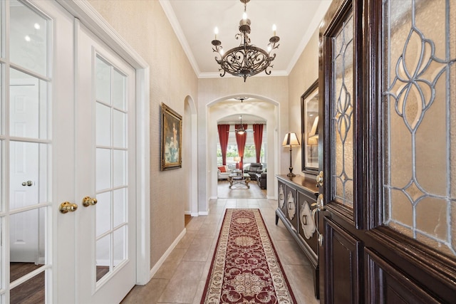 1815 Hanover Springs Ln, Richmond, TX 77406 - entryway with arched walkways, a chandelier, crown molding, light tile patterned floors, and french doors