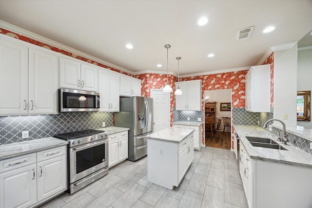 1815 Hanover Springs Ln, Richmond, TX 77406 - kitchen featuring stainless steel appliances, ornamental molding, white cabinetry, backsplash, and a kitchen island