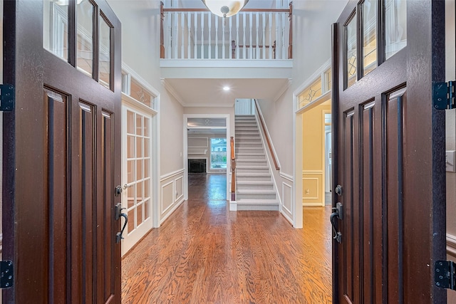 6018 Rapid Creek Ct, Houston, TX 77345 - entrance foyer featuring a high ceiling, wood finished floors, a decorative wall, wainscoting, and stairs