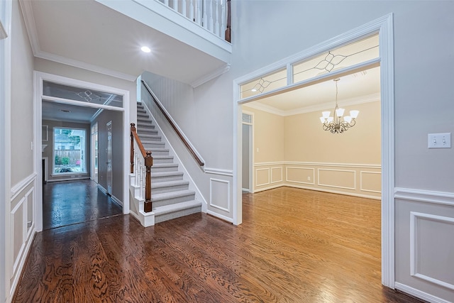 6018 Rapid Creek Ct, Houston, TX 77345 - entryway featuring a decorative wall, ornamental molding, stairway, wood finished floors, and a chandelier