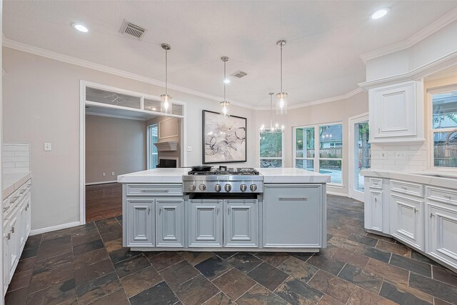 6018 Rapid Creek Ct, Houston, TX 77345 - kitchen with stainless steel gas cooktop, light countertops, stone tile floors, plenty of natural light, and ornamental molding