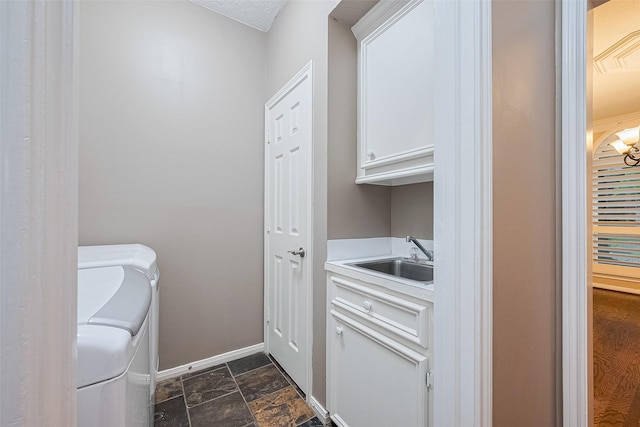 6018 Rapid Creek Ct, Houston, TX 77345 - laundry area featuring cabinet space, washer and dryer, and dark stone finish floors