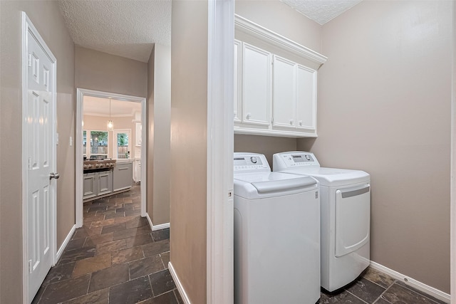 6018 Rapid Creek Ct, Houston, TX 77345 - washroom with separate washer and dryer, cabinet space, stone tile flooring, and a textured ceiling