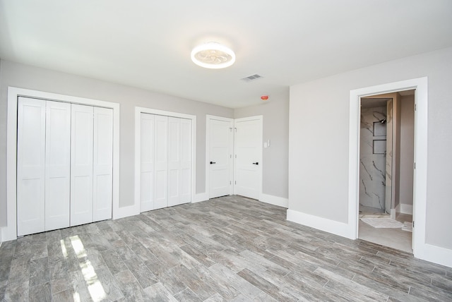 7618 Highmeadow Dr, Houston, TX 77063 - unfurnished bedroom with wood finished floors, two closets, and connected bathroom