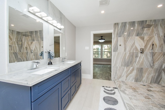 7618 Highmeadow Dr, Houston, TX 77063 - full bath with double vanity, a tile shower, recessed lighting, and wood finished floors