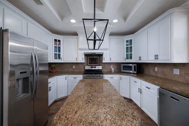 1600 Wimbledon Dr, Huntsville, TX 77340 - kitchen featuring appliances with stainless steel finishes, dark stone finish flooring, white cabinetry, glass insert cabinets, and light stone countertops