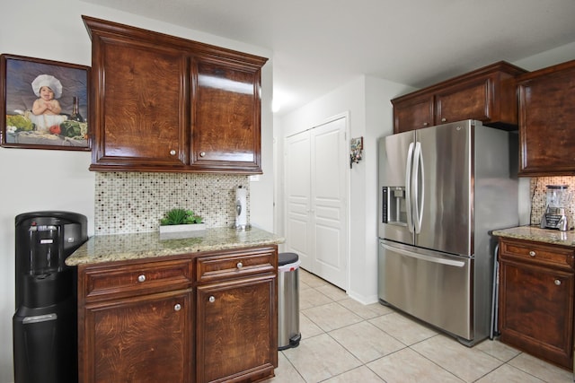 1202 Fairlane Sq, Channelview, TX 77530 - kitchen with stainless steel fridge with ice dispenser, light tile patterned floors, backsplash, and light stone counters