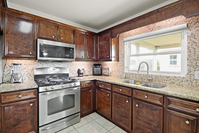 1202 Fairlane Sq, Channelview, TX 77530 - kitchen featuring stainless steel appliances, light stone countertops, decorative backsplash, light tile patterned floors, and dark brown cabinetry
