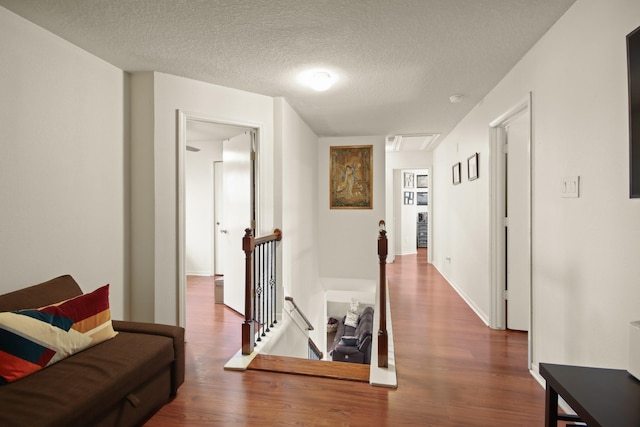 1202 Fairlane Sq, Channelview, TX 77530 - hall featuring an upstairs landing, wood finished floors, attic access, and a textured ceiling