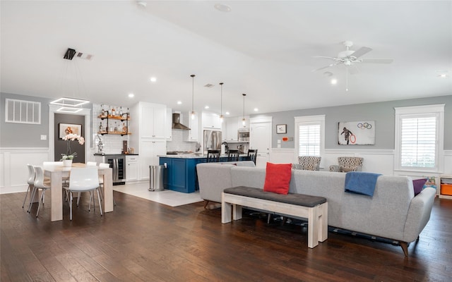 1719 Guese Rd, Houston, TX 77008 - living room featuring wine cooler, wainscoting, dark wood-type flooring, ceiling fan, and a decorative wall