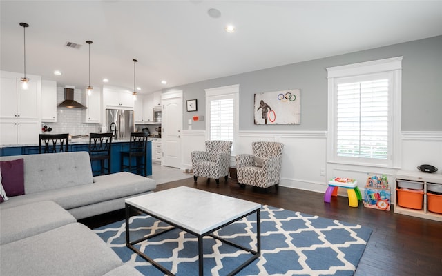 1719 Guese Rd, Houston, TX 77008 - living room with wainscoting, dark wood-style flooring, recessed lighting, and a decorative wall