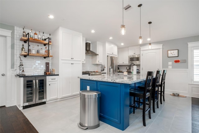 1719 Guese Rd, Houston, TX 77008 - kitchen featuring wine cooler, appliances with stainless steel finishes, wall chimney exhaust hood, decorative backsplash, and recessed lighting