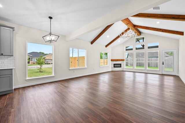 101 Callie St, Smithville, TX 78957 - unfurnished living room with a chandelier, dark wood finished floors, a glass covered fireplace, and recessed lighting