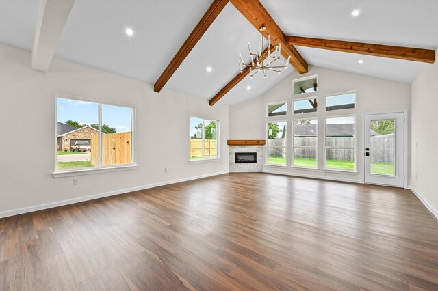 101 Callie St, Smithville, TX 78957 - unfurnished living room with beamed ceiling, wood finished floors, a glass covered fireplace, high vaulted ceiling, and recessed lighting