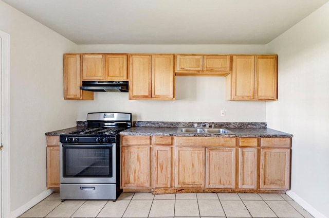 4637 Carmen St, Houston, TX 77051 - kitchen with stainless steel gas range oven, under cabinet range hood, dark countertops, and light tile patterned floors