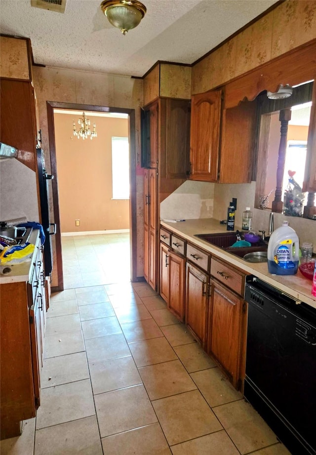 700 W 19th St, Port Arthur, TX 77640 - kitchen featuring black dishwasher, brown cabinets, a textured ceiling, light countertops, and a chandelier