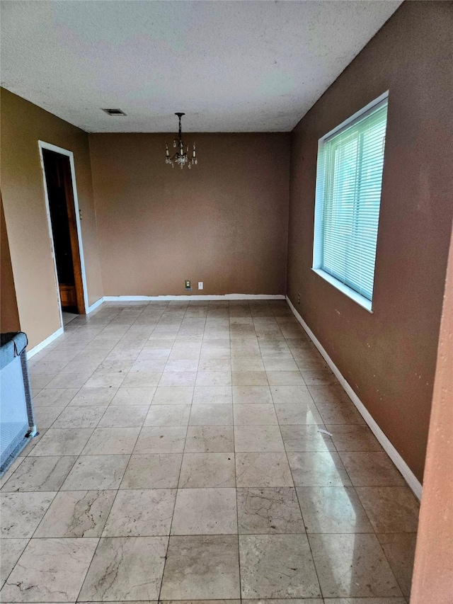 700 W 19th St, Port Arthur, TX 77640 - unfurnished dining area featuring a chandelier and a textured ceiling