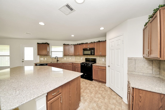 2702 Urban Glen Ct, Houston, TX 77038 - kitchen featuring black appliances, light stone counters, backsplash, a kitchen island, and recessed lighting